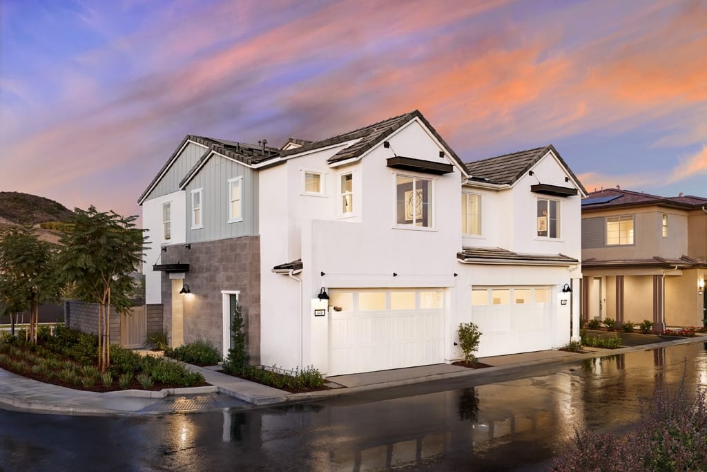 Duplex farmhouse style with white stucco, stone accents, and blue siding