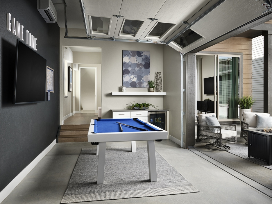 Interior view of a rec room option in Berkeley Homes' Painted Prairie Residence 2 plan, connecting to outdoor space via a roll-up garage door, from Eric Lucero Photography and NHTI.